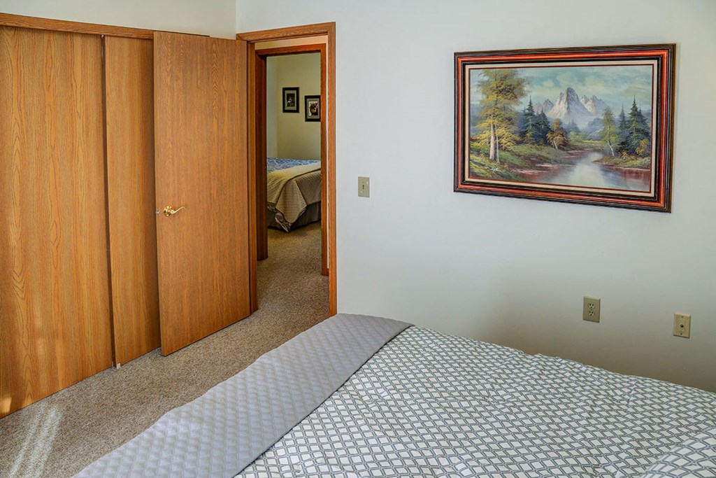 a bedroom with a bed and a painting on the wall