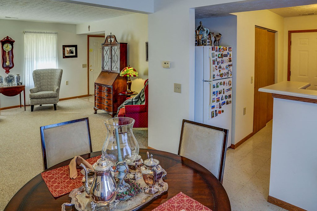 a dining room and living room with a table and a refrigerator