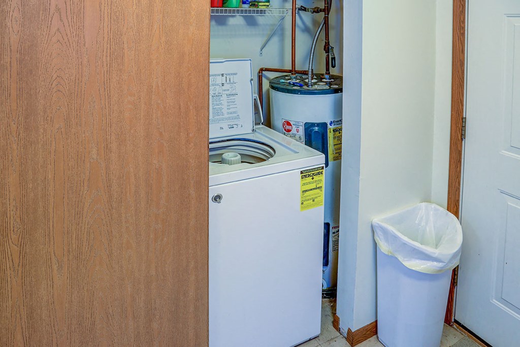 a small refrigerator and a washing machine in a small room