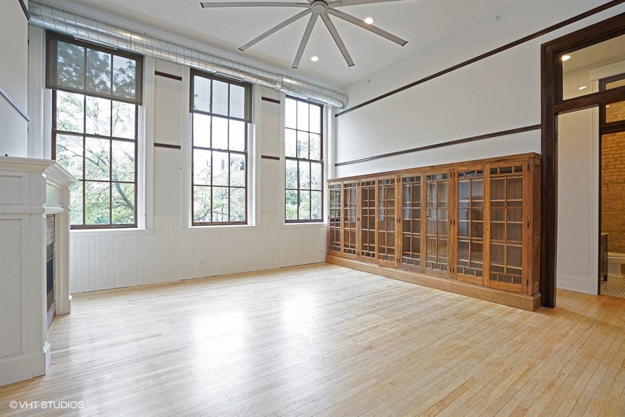 an empty living room with a wood floor and a large window