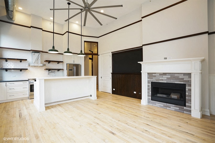 a large living room with a fireplace and a kitchen