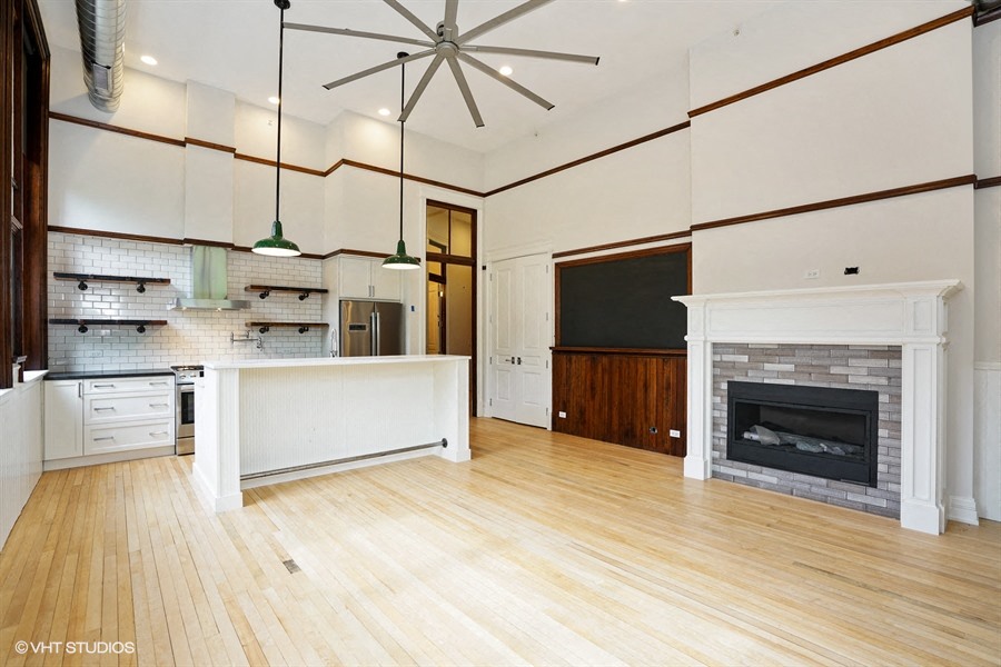 a large living room with a fireplace and a kitchen