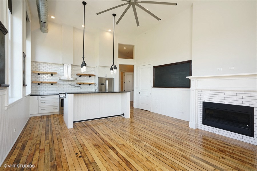 a large living room with a fireplace and a kitchen