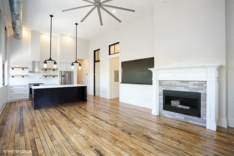 a large living room with a fireplace and a kitchen