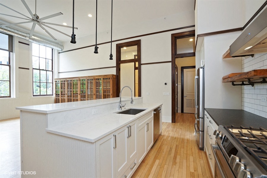 a large white kitchen with a large center island and a sink