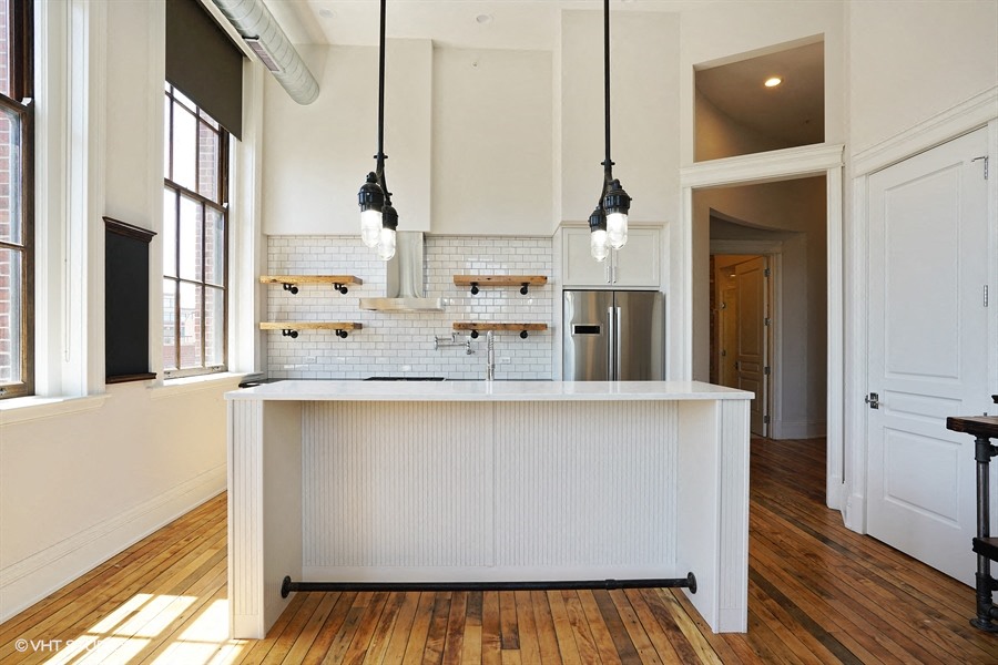 a white kitchen with a large island in the middle of it