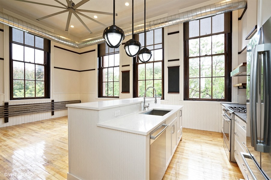 a large white kitchen with a large island and windows