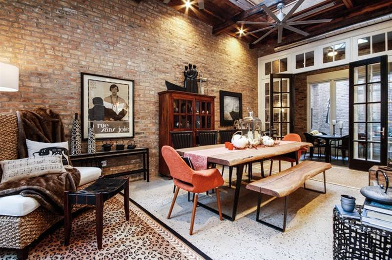 a dining room with a table and chairs and a brick wall