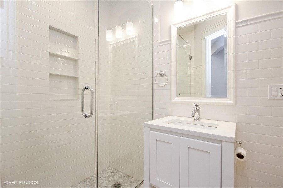 a white bathroom with a shower and a sink