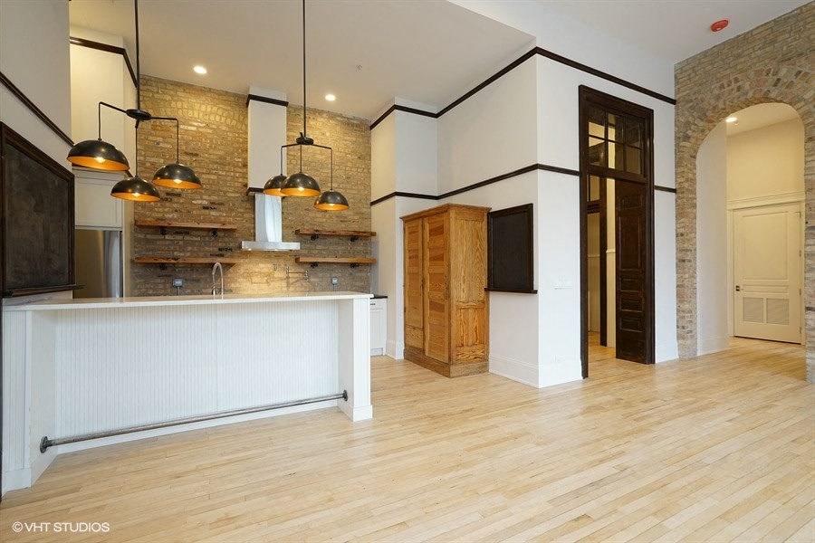 a large room with a kitchen and a wood floor