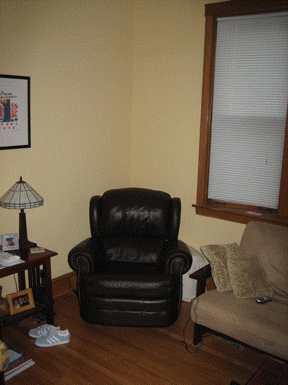a leather chair in a living room next to a window
