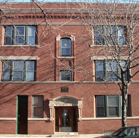 a red brick building with a tree in front of it