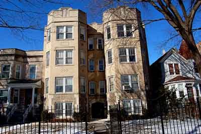 an apartment building with a fence in front of it