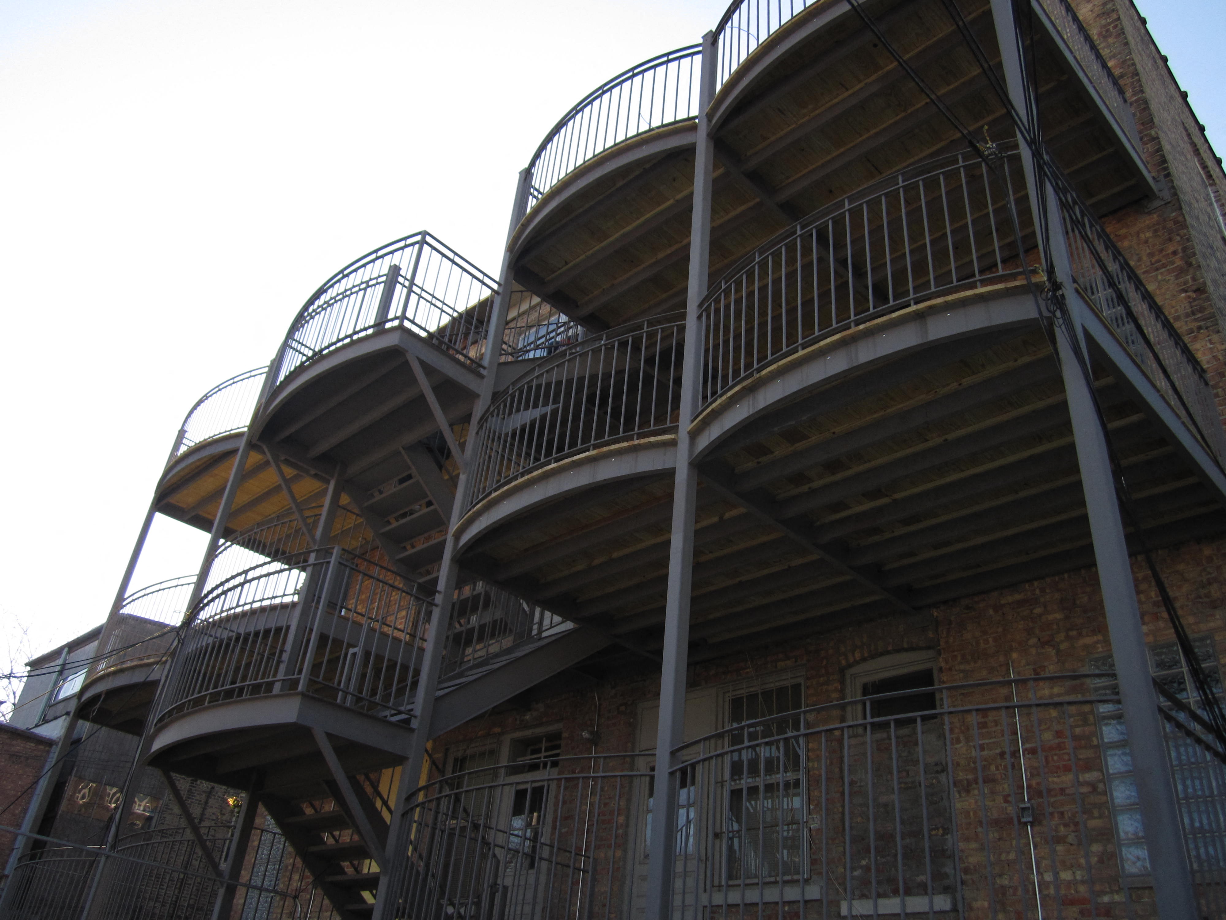 the side of a building with stairs and a balcony