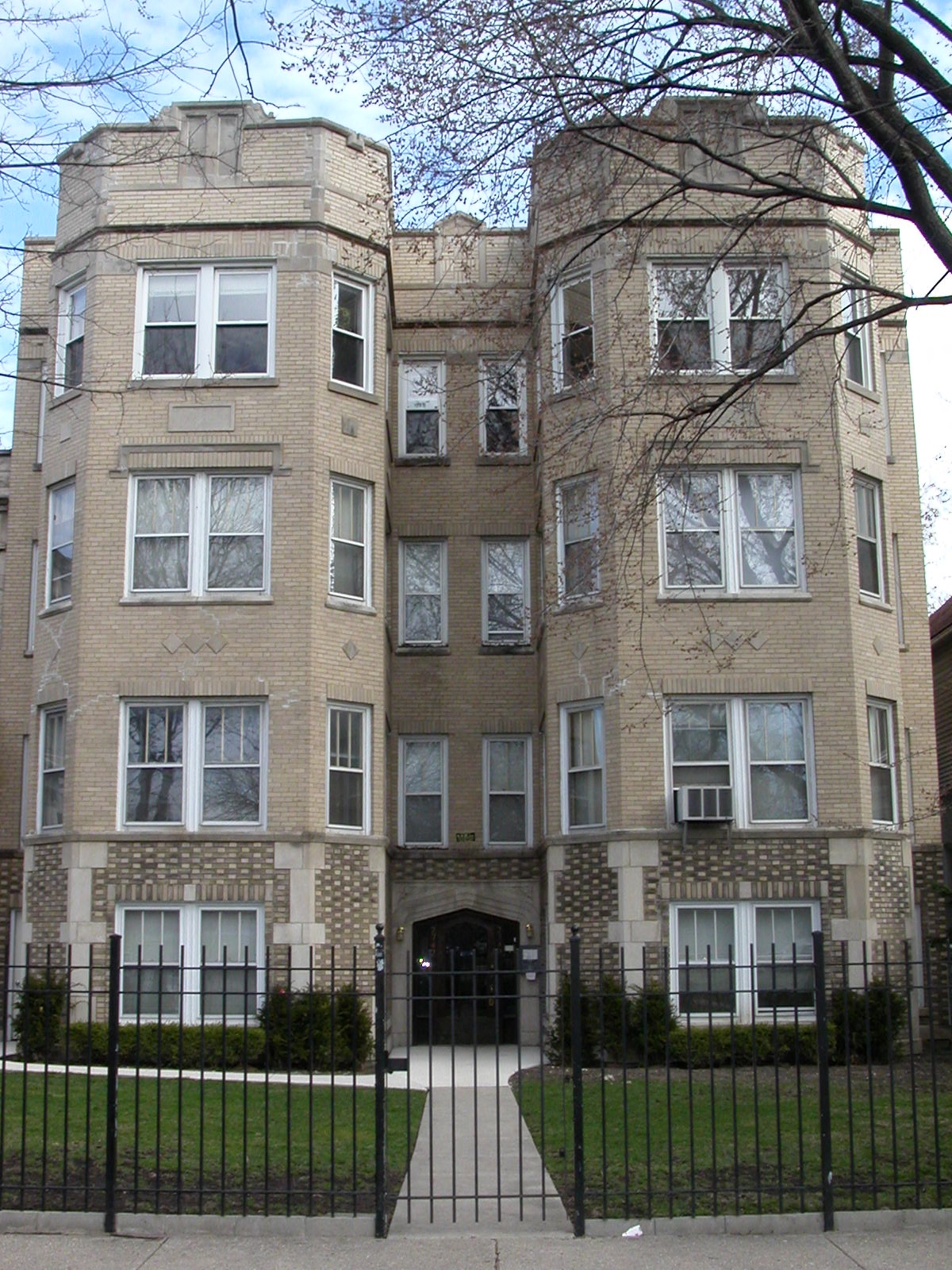 an apartment building with a black fence in front of it