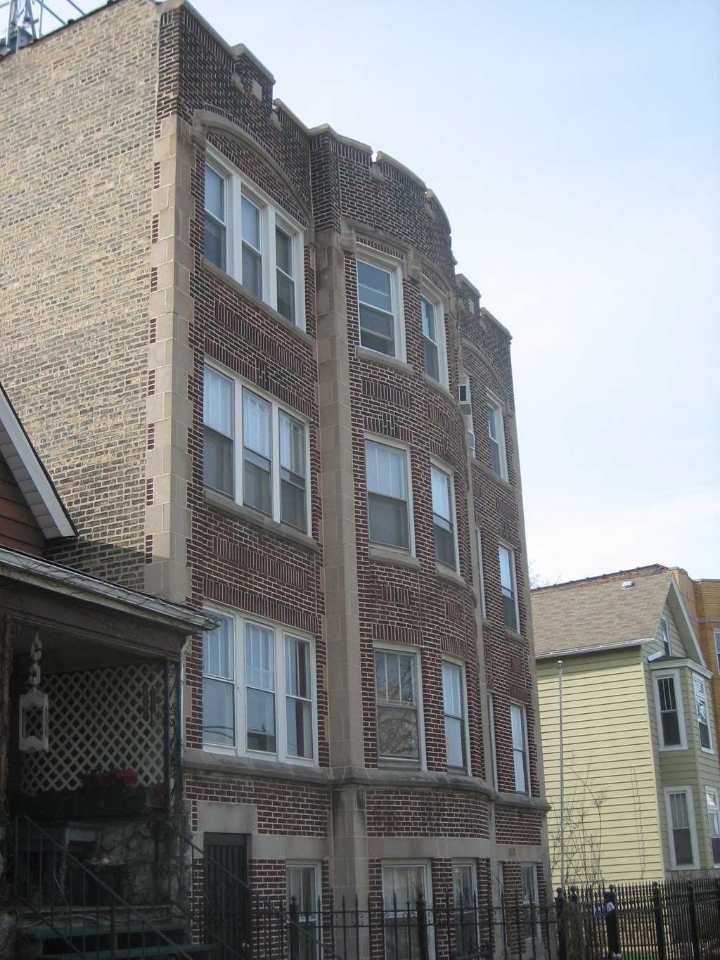 the side of a brick building with windows and a fence