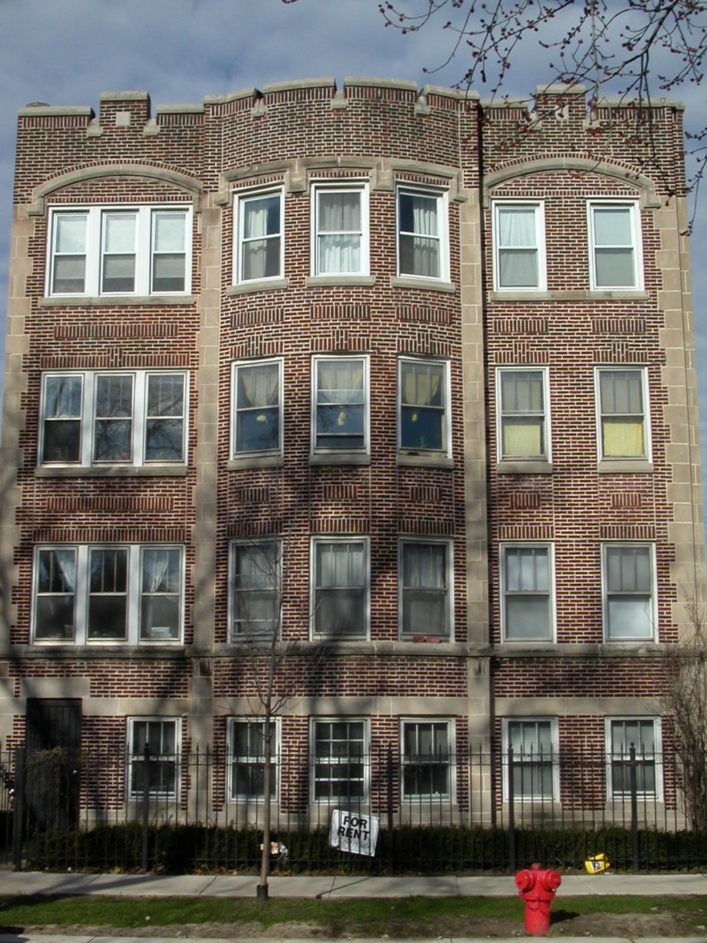a red fire hydrant in front of a brick building