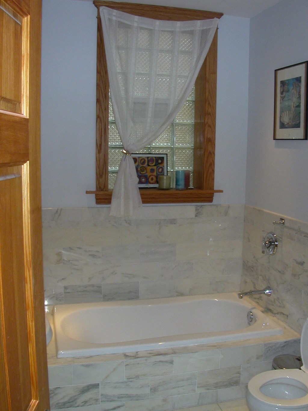 a bathroom with a tub and a toilet and a window