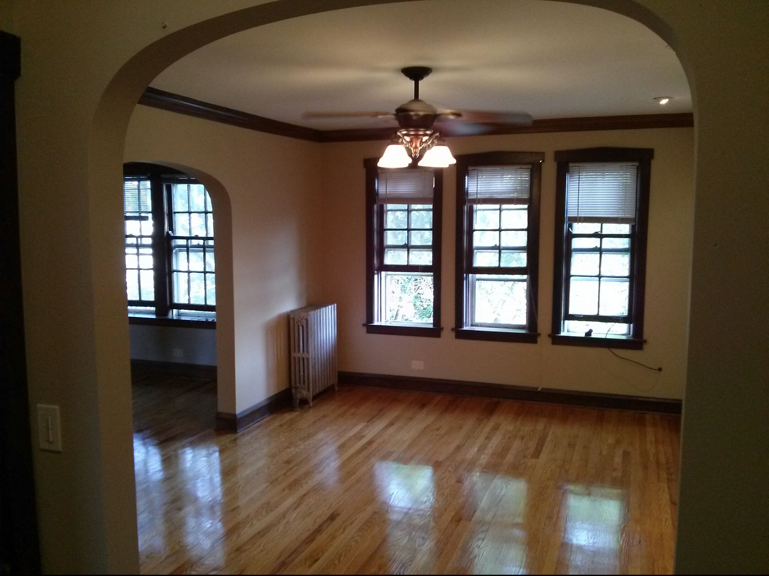 an empty living room with wood floors and windows