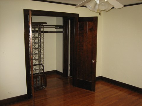 a closet in a living room with a wooden floor and a closet door open