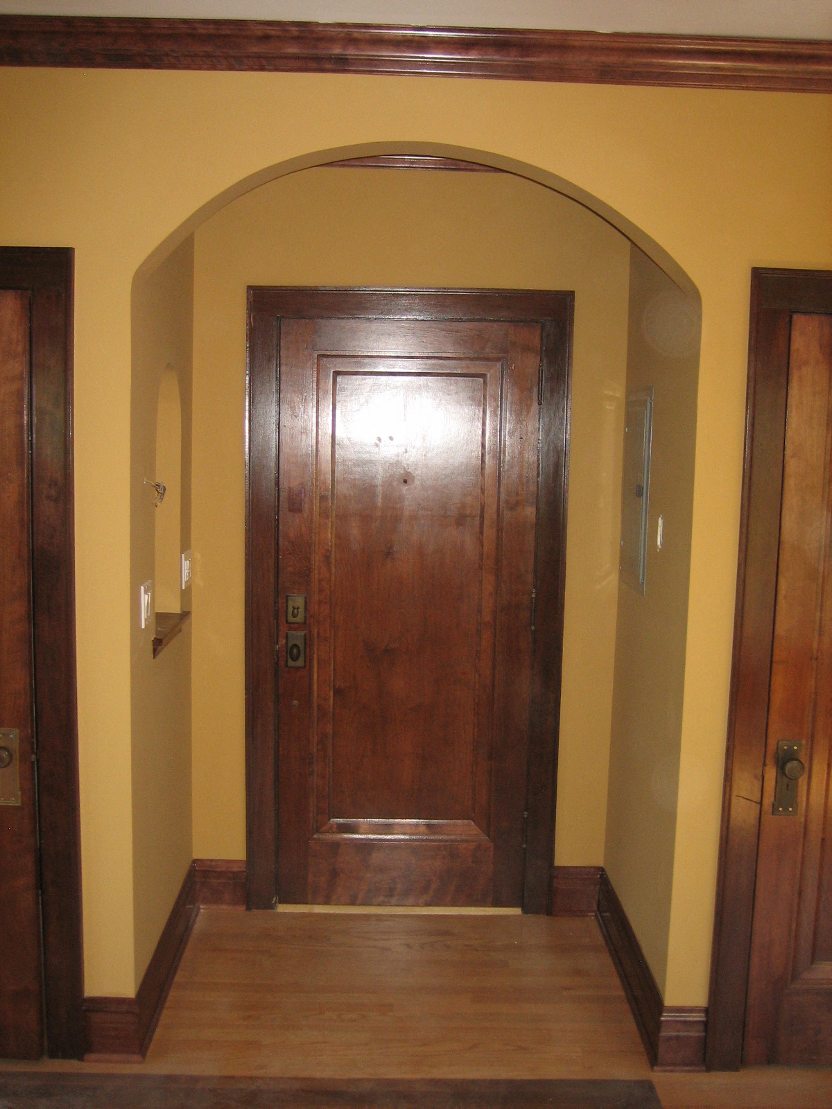 a large wooden door in a hallway with a yellow wall