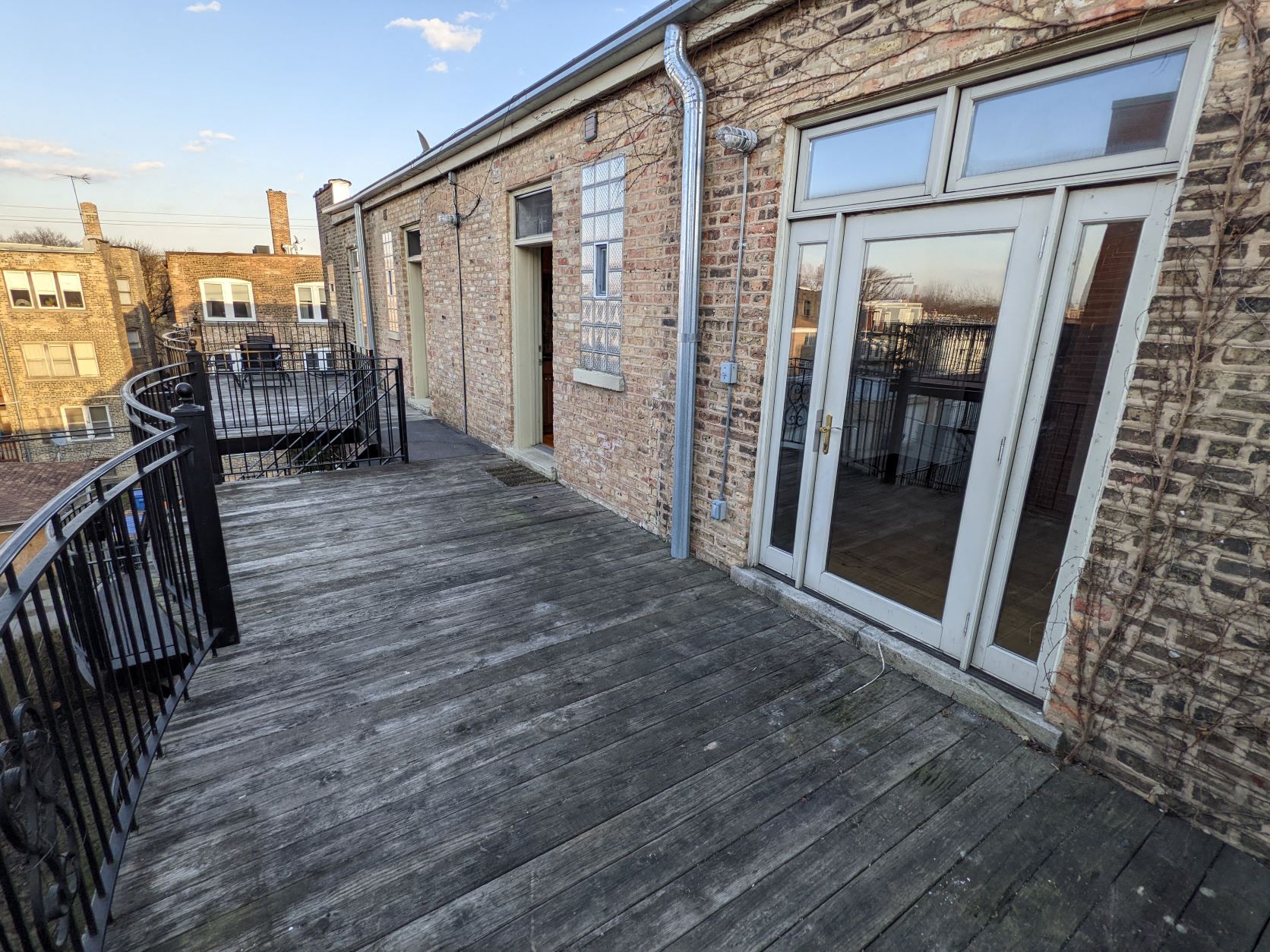 the balcony of a brick building with a wooden deck