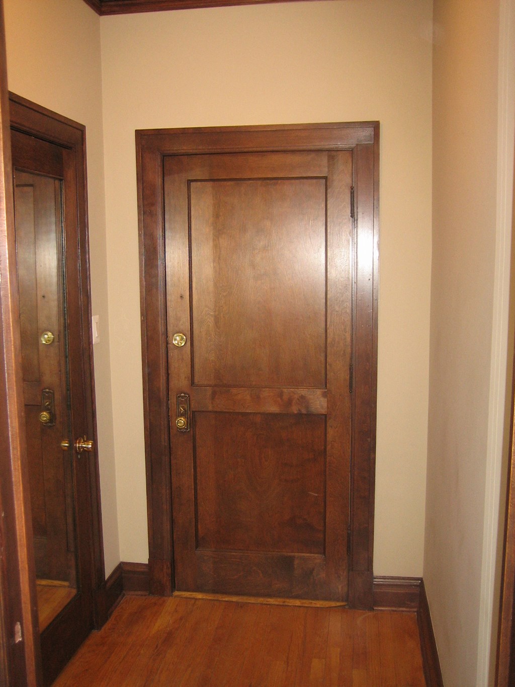 a wooden door in a hallway with a wooden floor