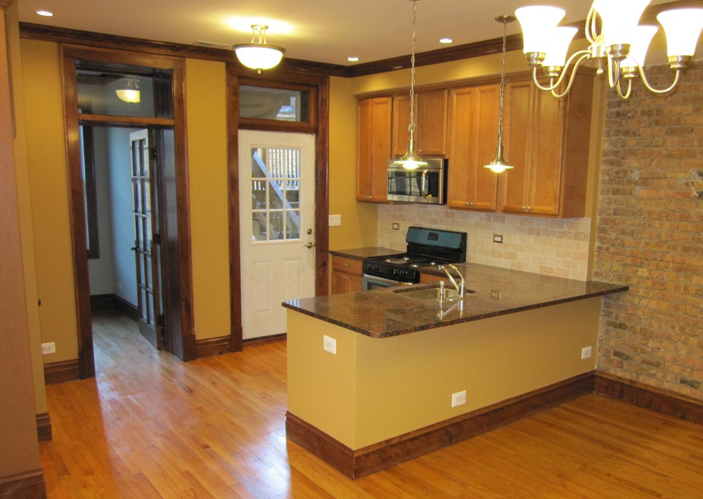 a kitchen with a large island and a door to a living room