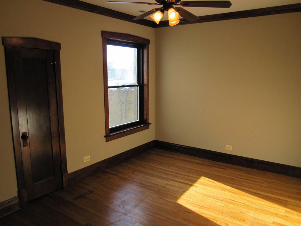 the living room with hardwood floors and a ceiling fan