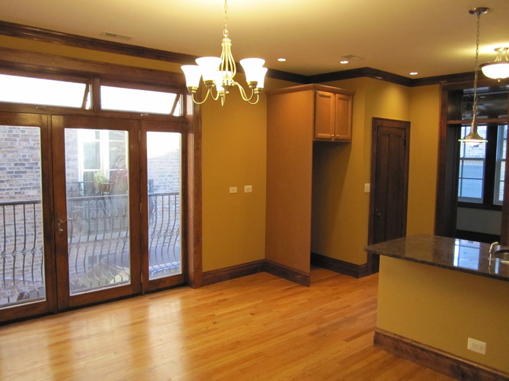 an empty living room with a sliding glass door to a balcony