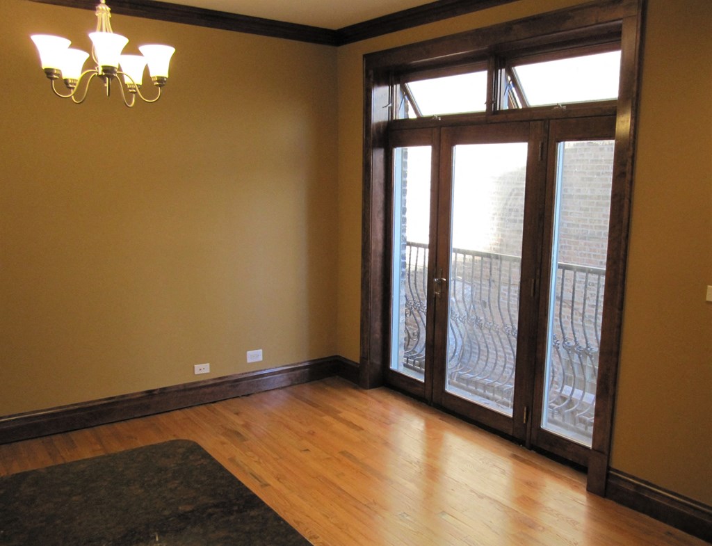 an empty living room with wood floors and a sliding glass door