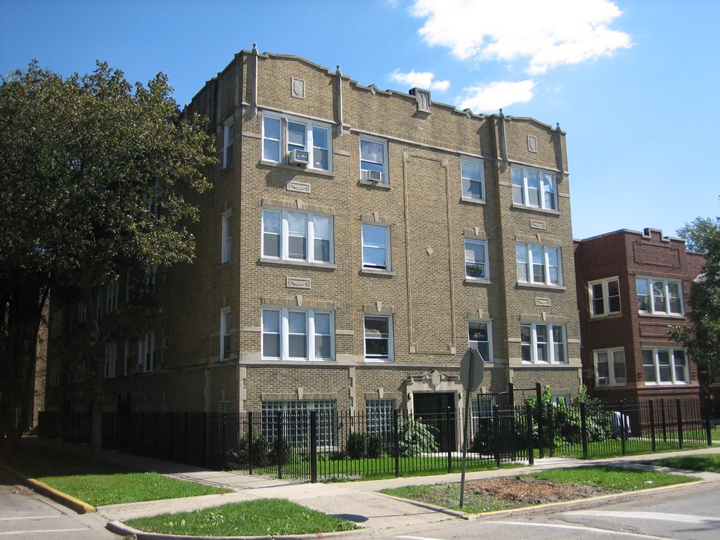 a tall brick building with a black fence in front of it