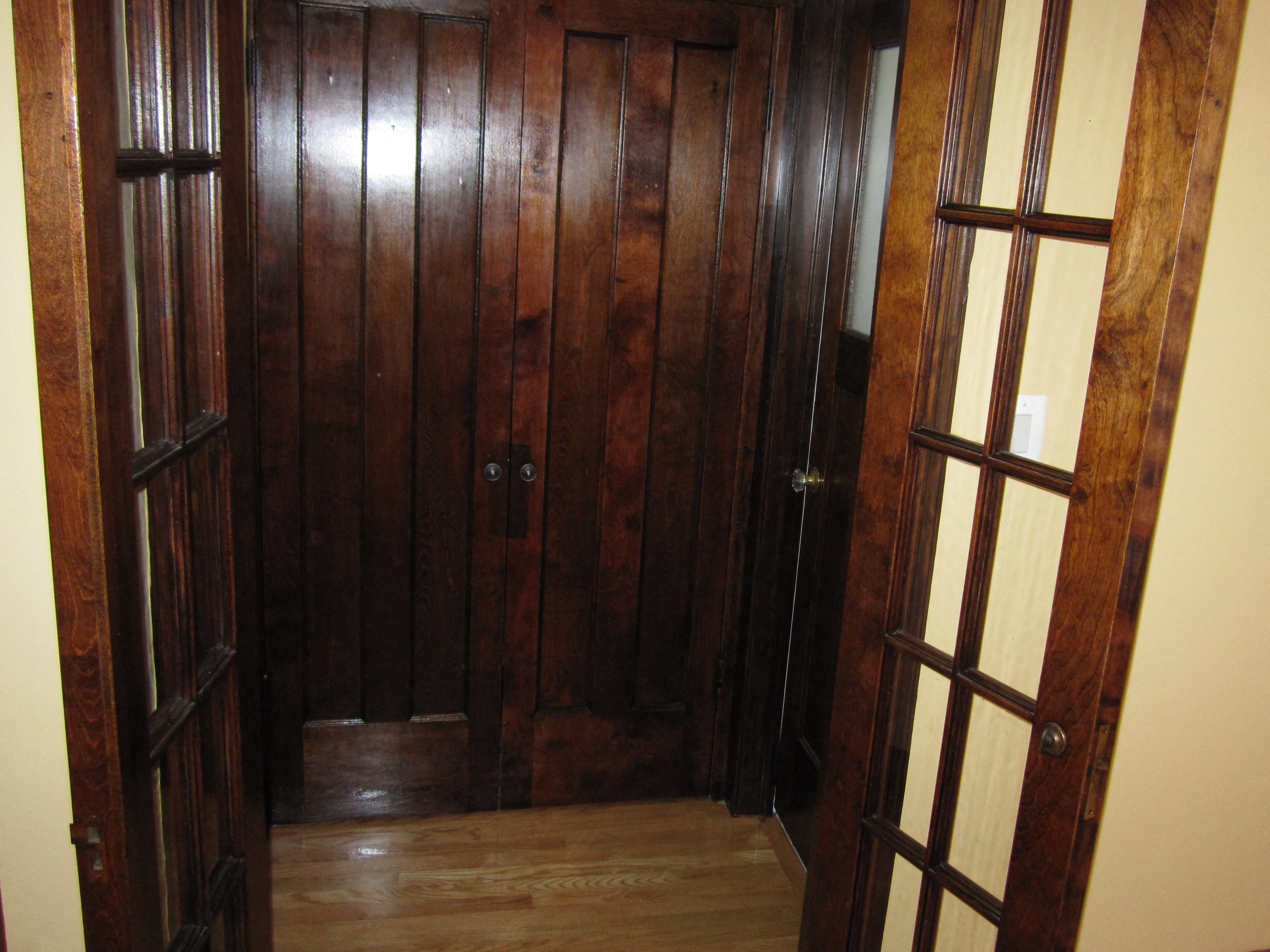 a small hallway with wood panels and glass doors