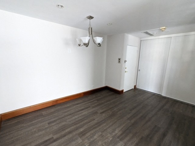an empty living room with wood floors and white walls