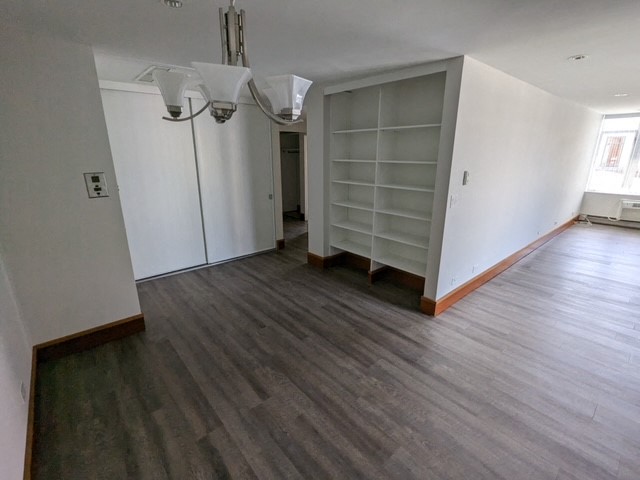 an empty living room with white walls and wood floors