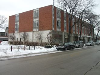 a large brick building with cars parked in the snow