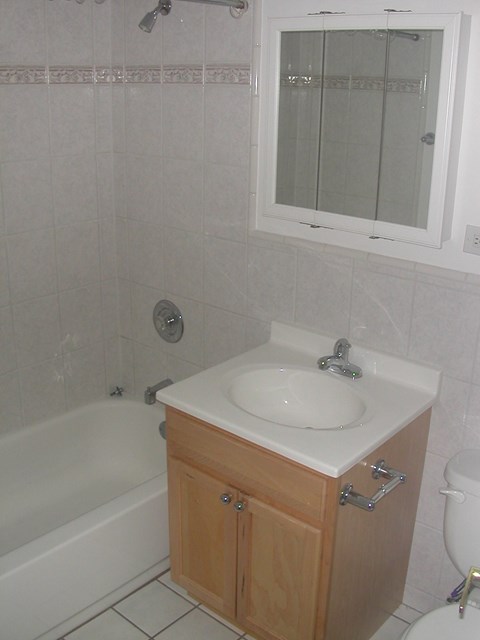 a bathroom with a sink and a tub and a mirror