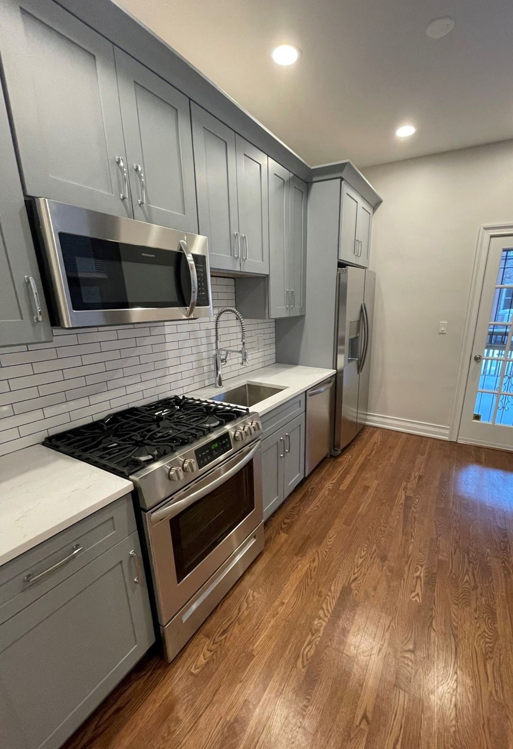 a kitchen with white cabinets and a stove and a microwave