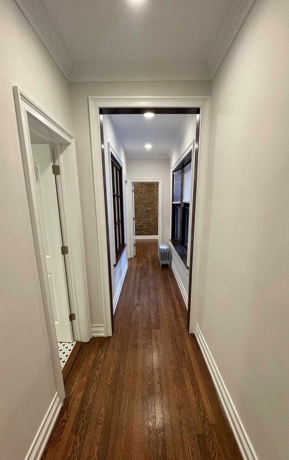 a look down the hallway of a house with wood floors