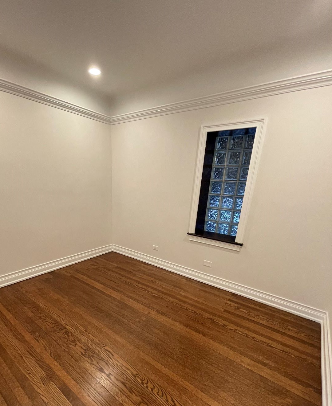 a living room with a window and wooden floors