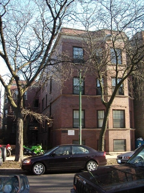 a tall brick building with cars parked in front of it