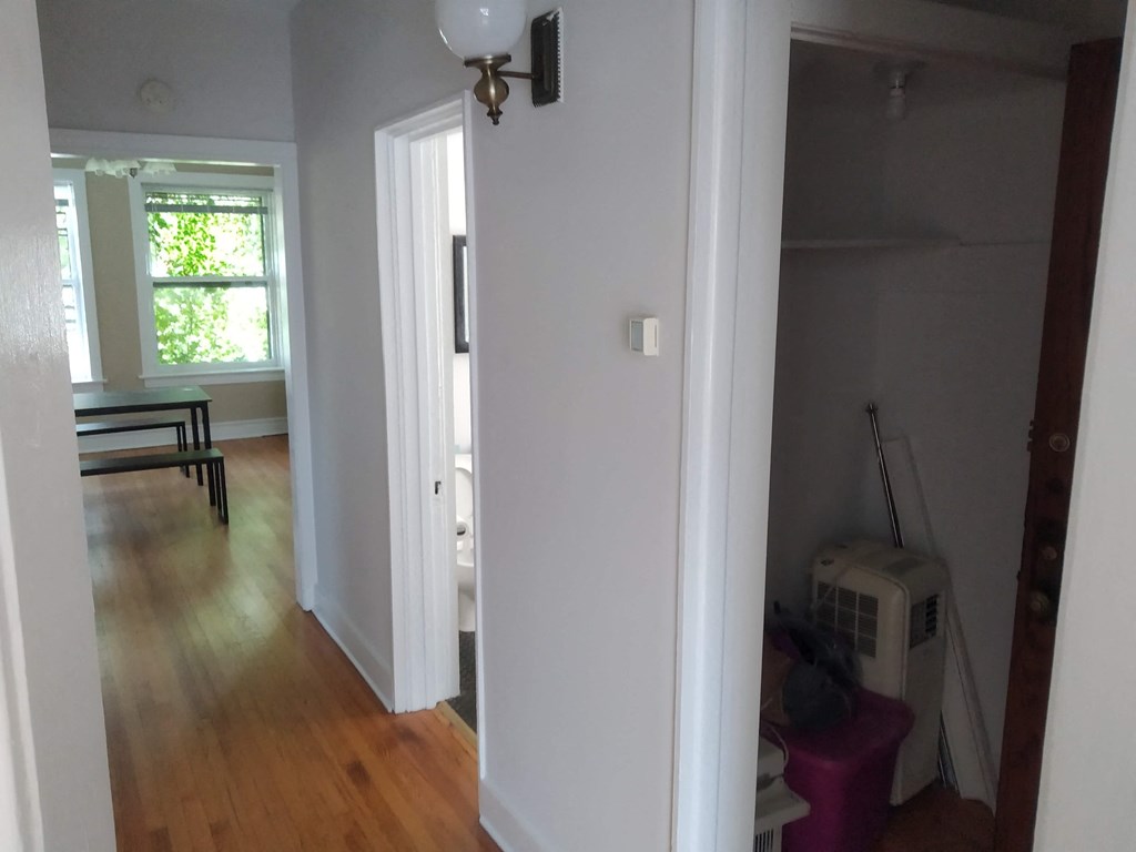 a living room with a white wall and wood floors