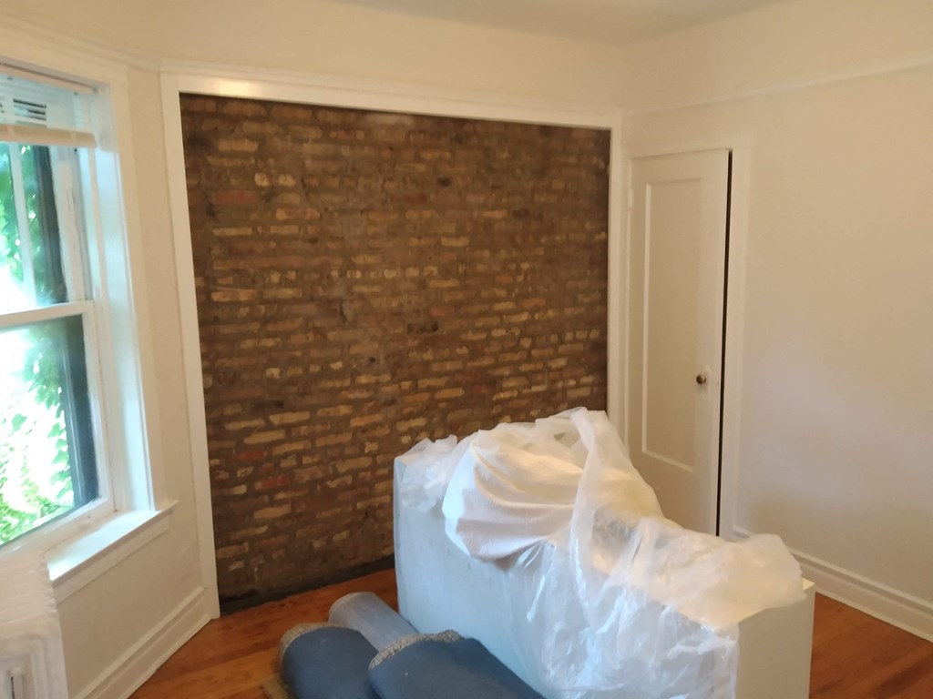 an empty room with a box and a brick wall
