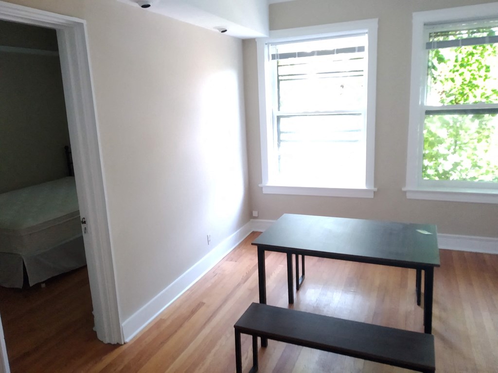 a dining room with a table and two windows