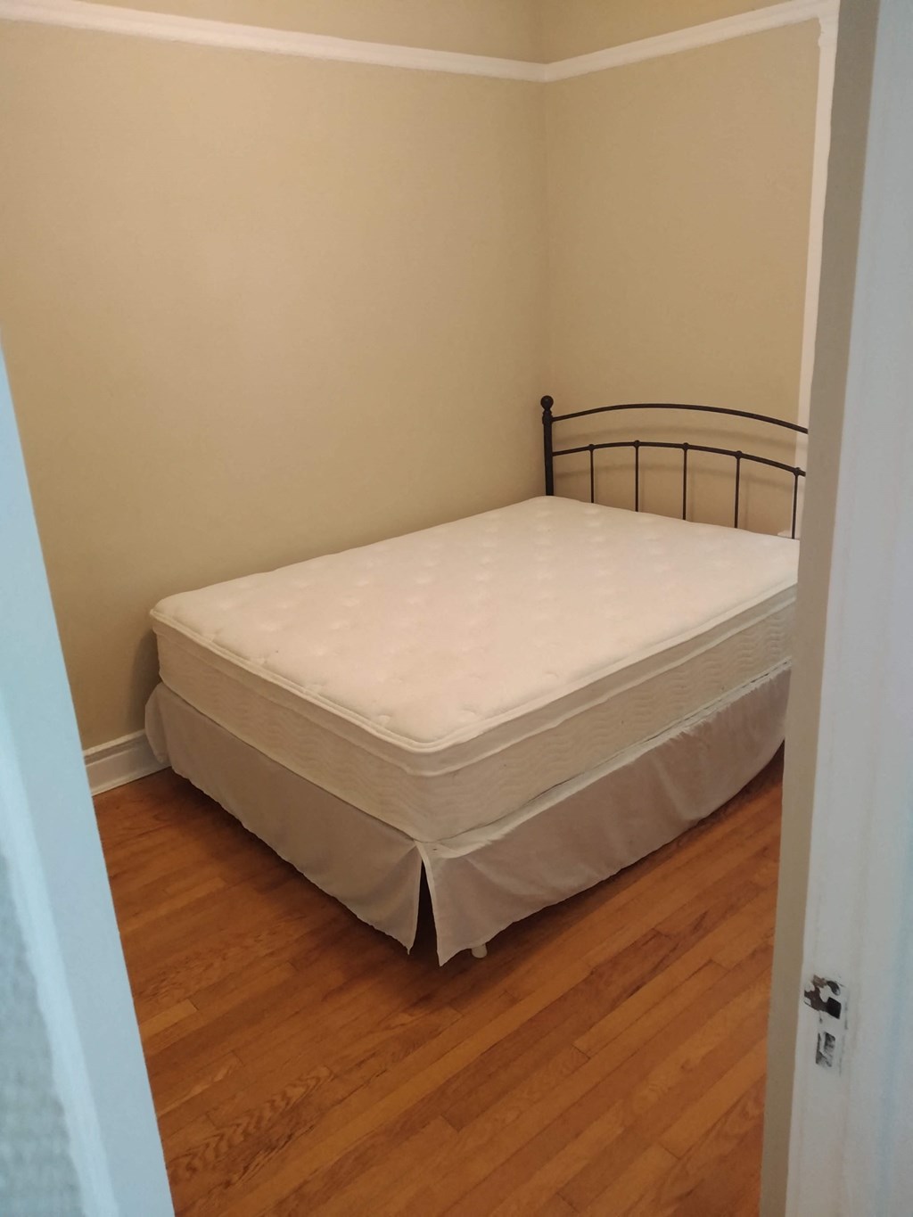 a bedroom with a bed and a wooden floor