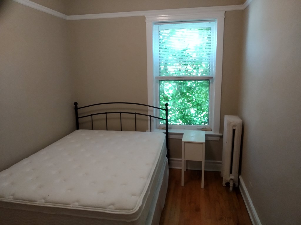 a small bedroom with a bed and a window