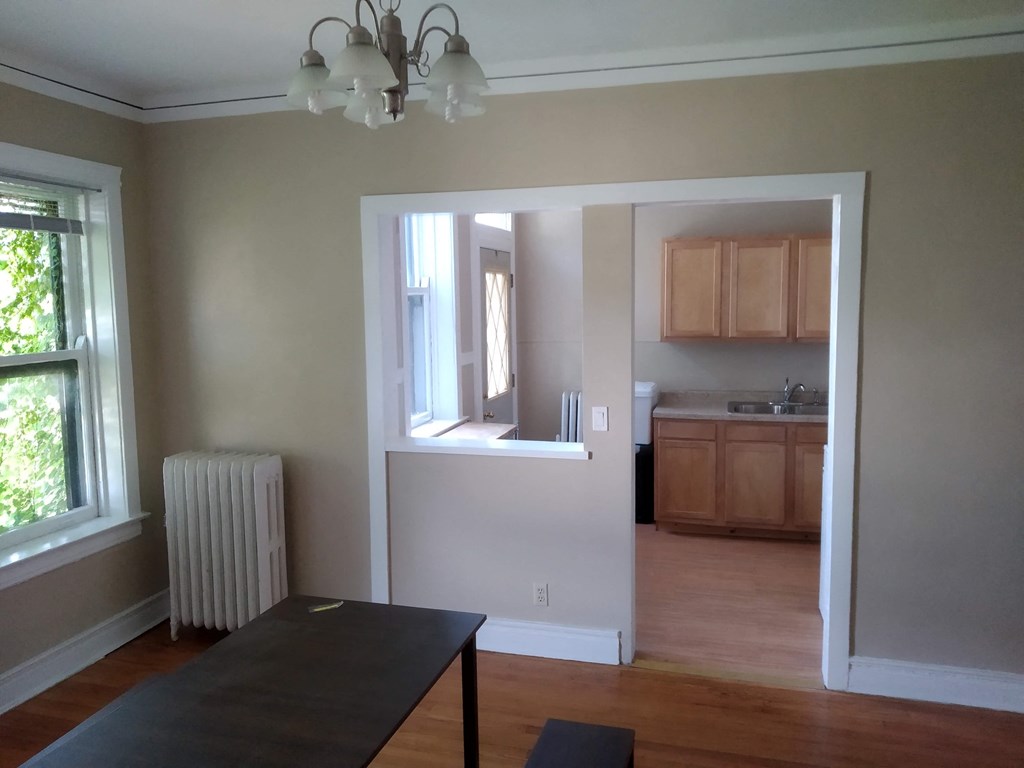 an empty living room with a dining room and a kitchen