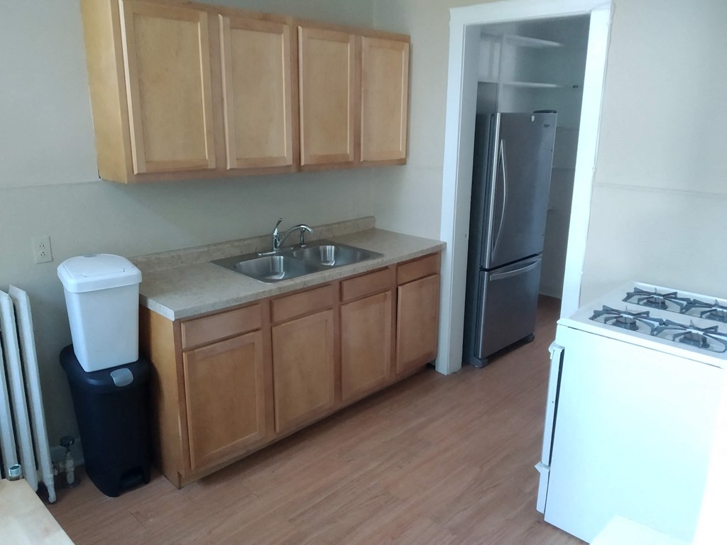 a kitchen with wooden cabinets and a sink and a refrigerator