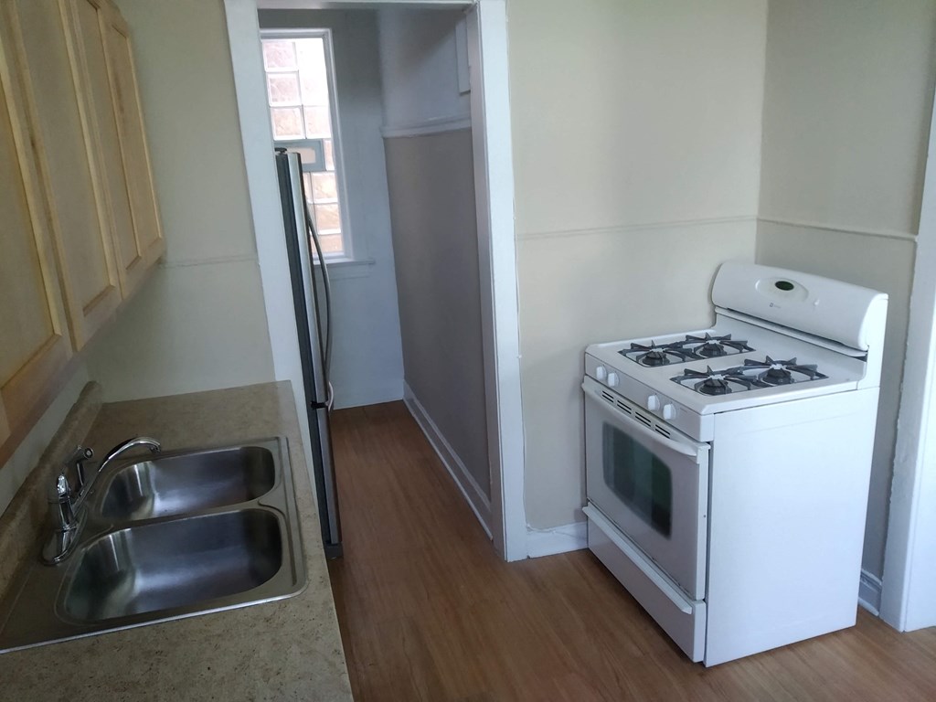 an empty kitchen with a stove and a sink