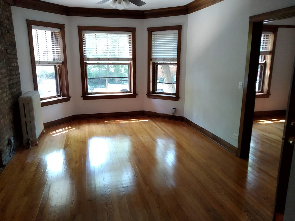 an empty living room with wooden floors and windows